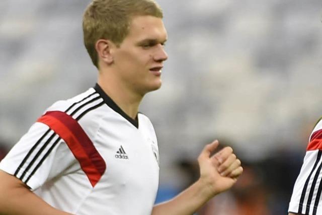 Weltmeister Matthias Ginter mit Pokal und Merkel